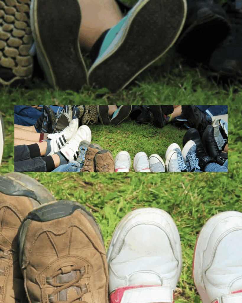 Verschiedene Schuhe von Teilnehmenden bilden einen Kreis auf einer grünen Wiese und symbolisieren Gemeinschaft und Vielfalt