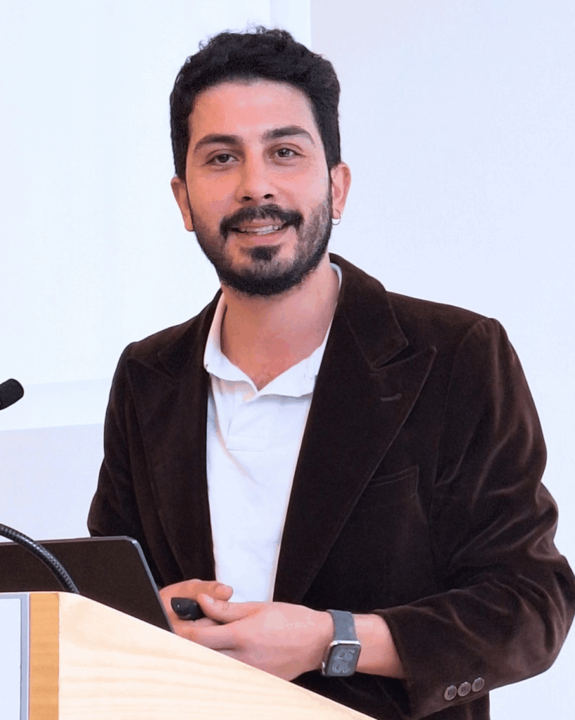 Ali Can spricht beim Gemeindepädagogischen Forum am 21. September 2026 im Haus Villigst. Er steht an einem Rednerpult und hält einen Vortrag zum Thema Demokratie.