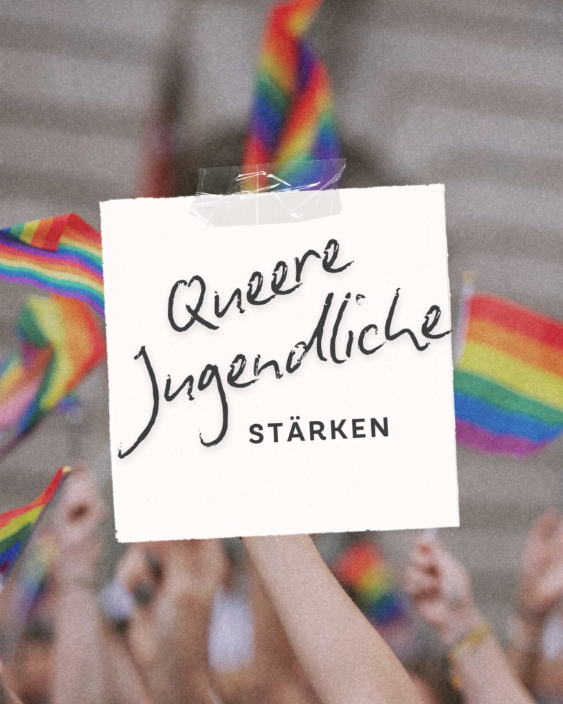 Schild mit der Aufschrift „Queere Jugendliche stärken“ vor Regenbogenfahnen bei einer Veranstaltung für Vielfalt, Akzeptanz und die Unterstützung queerer junger Menschen.